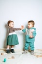 Baby fashion. Unisex gender neutral clothes for babies. Two Cute baby girls in neutral color palette cotton cloth