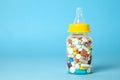 Baby feeding bottle filled with pills. With mother`s milk, the child gets everything the mother eats. Copy space for text