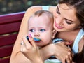 Baby feeding spoon by mother in park outdoor. Weaning . Royalty Free Stock Photo