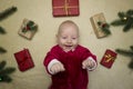 Baby feeling happy surrounded by christmas gifts