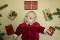 Baby feeling happy surrounded by christmas gifts