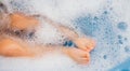 Baby feet in a blue bubble bath. Baby detergent, hygiene. Baby skin care. Background, texture of soap bubbles Royalty Free Stock Photo
