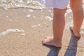 Baby feet close-up on the sand of the sea beach. Sea water washes the feet. Happy childhood. Rest at the sea. Summer Royalty Free Stock Photo