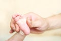 Baby feet in dad's hand with a blurred background