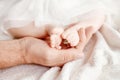 Baby feet in father hands. Tiny newborn baby`s feet on male hand Royalty Free Stock Photo