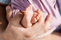 Baby feet in father hands. Tiny newborn baby`s feet on male hands closeup. Dad and his child. Happy Family concept. Beautiful Royalty Free Stock Photo