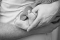 Baby feet in father hands. Tiny Newborn Baby`s feet on male shaped hands closeup. Dad and his Child. Happy Family concept Royalty Free Stock Photo