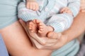 Baby feet in father hands. Tiny Newborn Baby`s feet on male Shaped hands closeup. Dad and his Child. Happy Family concept. Royalty Free Stock Photo