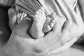 Baby feet in father hands. Tiny newborn baby`s feet on male hands closeup. Dad and his child. Happy Family concept. Beautiful Royalty Free Stock Photo