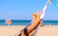 Baby feet on a hammock against the background of the blue sea and the beach. Royalty Free Stock Photo