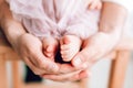 Baby feet in the hands of the father. Tiny legs of a newborn baby on male hands, close-up Royalty Free Stock Photo