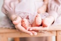 Baby feet in the hands of the father. Tiny legs of a newborn baby on male hands, close-up Royalty Free Stock Photo