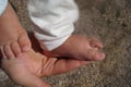 Baby feet and legs in pants on a mother`s hand Royalty Free Stock Photo