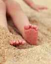 Baby feet lying on yellow beach