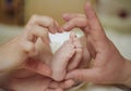 Baby feet in mom and dad palms. Newborn baby feet in mother hands, shape like a lovely heart. Happy family concept. Royalty Free Stock Photo