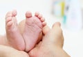 Baby Feet in Mother Hands. New Born Kid Foot Royalty Free Stock Photo