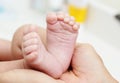 Baby Feet in Mother Hands. New Born Kid Foot Royalty Free Stock Photo