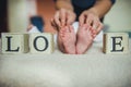 Baby feet in mother hands. Tiny Newborn `s on female Heart Shaped closeup. Royalty Free Stock Photo