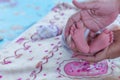 Parents hands holding small newborn baby girl feet Royalty Free Stock Photo