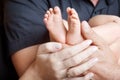 Baby feet in parents hands. Tiny Newborn Baby`s feet on parents shaped hands closeup. Parents and they Child. Happy Family concep Royalty Free Stock Photo