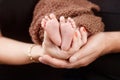 Baby feet in parents hands. Tiny Newborn Baby`s feet on parents shaped hands closeup. Parents and they Child. Happy Family concep Royalty Free Stock Photo