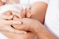 Baby feet in parents hands. Tiny Newborn Baby`s feet on parents.on white background Royalty Free Stock Photo