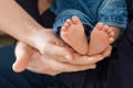 Baby feet in parents hands. Tiny Newborn Baby`s feet on ffamily hands closeup. Mom, dad and they child. Happy Family concept. Royalty Free Stock Photo