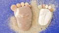 Baby feet shape made with pebbles on the beach with sand and blue background. Horizontal banner Royalty Free Stock Photo