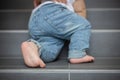 Baby feet on the stairs, toddler climbs the steps Royalty Free Stock Photo