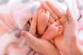 baby feet of a toddler in the hands of a loving mother