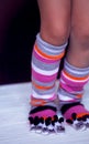 Baby feet in warm, long multicolored socks with toes Royalty Free Stock Photo