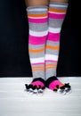 Baby feet in warm, long multicolored socks with toes Royalty Free Stock Photo
