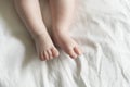 Baby feet on the white background of the bed. Care, parenthood, protection concept. Royalty Free Stock Photo