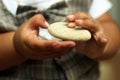 Baby fingers holding white stone. Hands of 1 year old baby