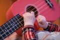 Baby fingers plays guitar. Ukulele strings and frets Royalty Free Stock Photo