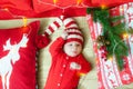 Baby first christmas. Beautiful little baby celebrates Christmas. New Year`s holidays. Baby with santa hat with gift.