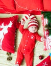 Baby first christmas. Beautiful little baby celebrates Christmas. New Year`s holidays. Baby with santa hat with gift.