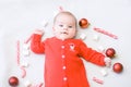 Baby first christmas. Beautiful little baby celebrates Christmas. New Year`s holidays. Baby with Christmas candy and marshmallows