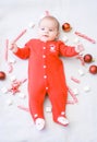 Baby first christmas. Beautiful little baby celebrates Christmas. New Year`s holidays. Baby with Christmas candy and marshmallows