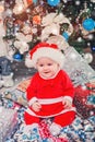 Baby first Christmas. New Year holidays. Baby with santa hat with gift. Royalty Free Stock Photo