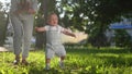 baby first steps in the park. happy family in the park on vacation. mother teaches baby son to take the first steps on Royalty Free Stock Photo