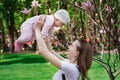 Baby flies in mothers hands. Mom and little daughter playing on background of nature