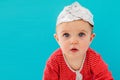 Baby in a foil hat sits on a blue background