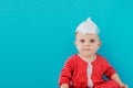 Baby in a foil hat sits on a blue background