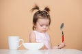 Baby food, babies eating. Portrait of cute Caucasian child kid with spoon. Hungry messy baby with plate after eating