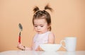 Baby food, babies eating. Portrait of cute Caucasian child kid with spoon. Hungry messy baby with plate after eating