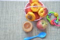 Baby food, baby fruit mashed in a glass jar, peach, beautiful peaches in a basket, children`s toy. apple