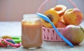 Baby food, baby fruit mashed in a glass jar, peach, beautiful peaches in a basket, children`s toy. apple Royalty Free Stock Photo