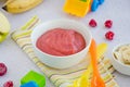 Baby food. Homemade apple puree or sauce with banana and raspberries in a bowl with a spoon on a light background. Healthy food. Royalty Free Stock Photo