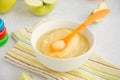 Baby food. Homemade apple puree or sauce from organic apples in a bowl with a spoon on a light background with fresh apples. Royalty Free Stock Photo